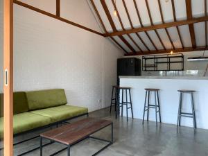 a living room with a couch and a counter with stools at Villa YAMI Uluwatu Private Infinity Pool Jungle Views in Ungasan