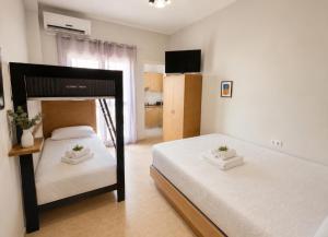a bedroom with two beds and a television in it at Aurora Apartments Stavros in Stavros