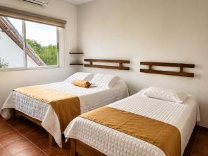 two beds in a room with a dog laying on the bed at Hotel Yaltas Inn in Tola