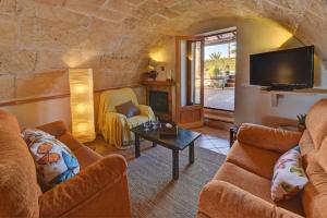 Una sala de estar con dos sofás y un televisor. en Finca Hort De Sa Barrala, en Ses Covetes