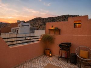 a balcony with a table and a stool on a building at Cozy Guesthouse in Aourir near Tamraght in Aourir