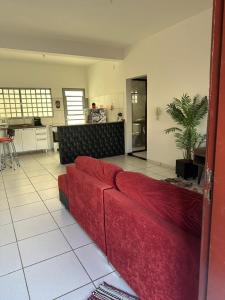 a red couch in a living room with a kitchen at Ap 07 mazzonetto in Primavera do Leste