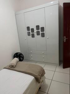a bedroom with a bed and a large cabinet at Ap 07 mazzonetto in Primavera do Leste +2 photos