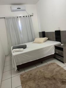 a bedroom with a bed with a window and a rug at Ap 07 mazzonetto in Primavera do Leste