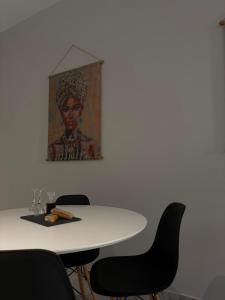 a table with chairs and a painting on the wall at Vt Homes in Corfu +26 photos