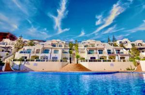 a large building with a swimming pool in front of it at Tiguert serenity in Tiguert