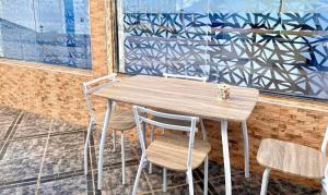 a wooden table and chairs in front of a building at Las Brisas Beachfront Mekad private in Oued Laou