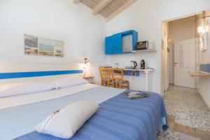 a bedroom with a blue and white bed and a kitchen at La collina sui trabocchi in Ortona