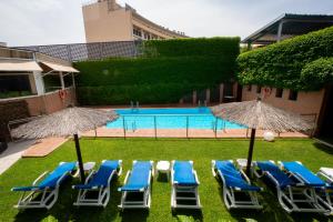 a group of chairs and umbrellas next to a pool at Hotel Reston Valdemoro in Valdemoro