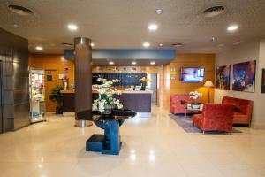 a lobby with a table with flowers on it at Hotel Reston Valdemoro in Valdemoro