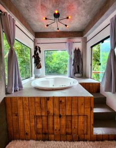 a bathroom with a large tub in a room with windows at Studio Mata dos Curiós in Petrópolis