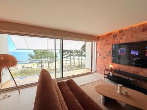 a living room with a couch and a large window at Escale élégante à la mer Duplex neuf en front de mer in Bénodet