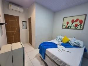 a bedroom with a bed with blue sheets and yellow pillows at Hostel 4 Cantos in Olinda +26 photos