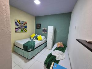 a small room with a bed and a cabinet at Hostel 4 Cantos in Olinda