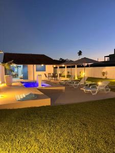 a house with a patio with chairs and umbrellas at night at Califeira do Patacho in Pôrto de Pedras