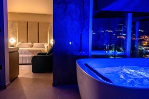a bathroom with a tub in a room with a bedroom at Nuna Hotel & Apartments in Vlorë +288 photos