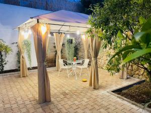 a gazebo with a table and chairs under it at Room24 Relax & Wellness in Genzano di Roma