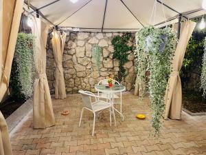 a tent with a table and chairs in a courtyard at Room24 Relax & Wellness in Genzano di Roma