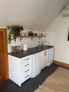 a kitchen with white cabinets and a sink at Spacious 1 Bed apartment City centre in Palmerston North
