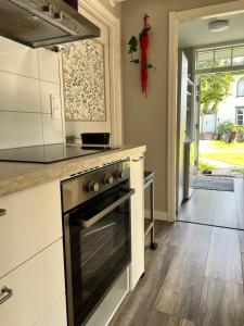 a kitchen with a stove top oven next to a hallway at Sköna Rum Fryksta in Kil