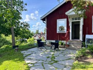 a red barn with a table and chairs in front of it at Sköna Rum Fryksta in Kil