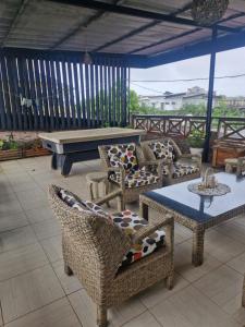 a patio with chairs and a table and a bench at Villa Miradie in Grand-Bassam