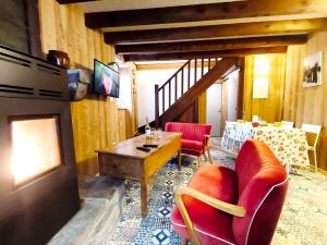 a living room with a table and red chairs at Apparts'Hôtel Aspe in Bedous