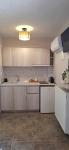 a kitchen with white cabinets and a sink at House Kiriaki in Sarti
