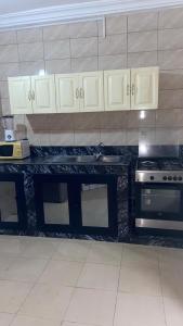 a kitchen with a counter top and a stove at New ACROPOLE in Komé