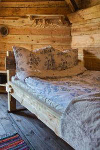 a bed in a wooden room in a cabin at Agroturystyka Lasy Północy Leśna Chata in Dzierniakowo