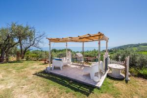 a gazebo with a bench and a table in a yard at La collina sui trabocchi in Ortona
