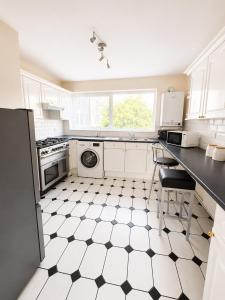 a kitchen with a black and white checkered floor at Spacious 2 bedroom apartment near Wembley stadium with free parking in London