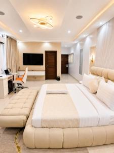 a large white bedroom with a large bed and a desk at NO 5 Hotel in Lekki