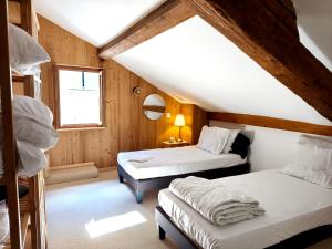 a attic room with two beds and a window at Apparts'Hôtel Aspe in Bedous
