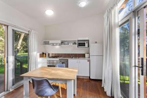 a kitchen with white appliances and a table and chairs at The Point Villa in Cowes