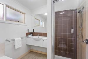 a white bathroom with a sink and a shower at The Point Villa in Cowes