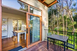 a house with a balcony with a table and a bench at The Point Villa in Cowes