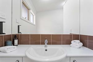 a white bathroom with a sink and a mirror at The Point Villa in Cowes
