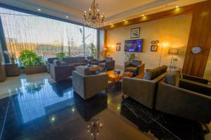 a large living room with couches and a chandelier at Erbil Quartz Hotel in Erbil