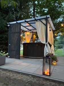 a gazebo with curtains and lights on a patio at Gorczańska Chatka in Osobie