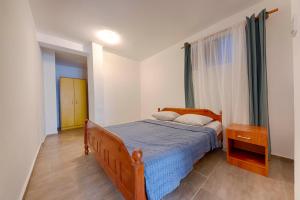 a bedroom with a bed with a blue comforter at FIRST ROW Sea View in Šušanj