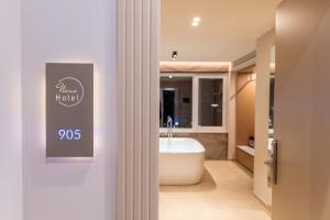 a bathroom with a white tub and a sink at Nuna Hotel & Apartments in Vlorë