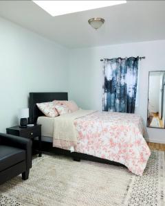 a bedroom with a bed and a chair and a mirror at SEVENeCOZY in Edgemere