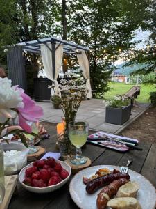 a wooden table with plates of food and drinks at Gorczańska Chatka in Osobie