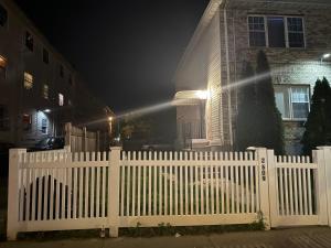 a white picket fence in front of a house at night at SEVENeCOZY in Edgemere +5 photos
