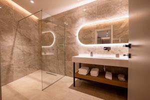 a bathroom with a sink and a shower at Nuna Hotel & Apartments in Vlorë