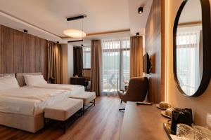 a hotel room with a bed and a mirror at Hotel Aleksandrija in Ohrid