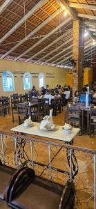 a dining room with tables and people sitting at tables at Pousada das Cores Cocais in Barão de Cocais