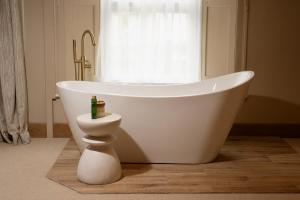 a white bath tub in a bathroom with a window at Budock Vean Hotel and Spa in Falmouth +100 photos