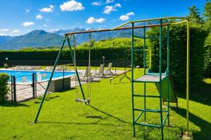 a swing set in a yard next to a pool at Calla in Colico